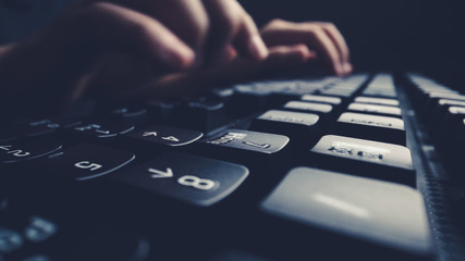 Close-up soft-focus finger typing on keyboard. Man hand using laptop computer in office....