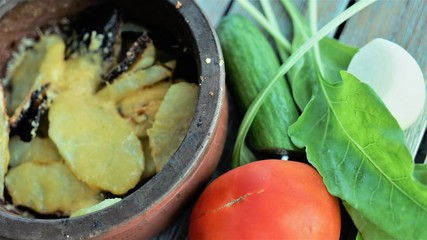roasted potato in clayware and fresh vegetables 