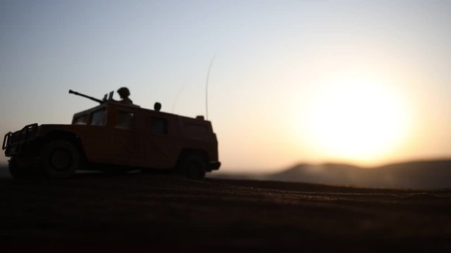 War Concept. Military silhouettes fighting scene on war foggy sky background at sunset. Armored vehicles with soldiers ready to attack. Artwork decoration. Selective focus