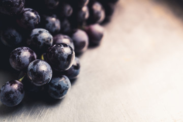 Ripe black grape on the rustic background. Selective focus. Shallow depth of field.