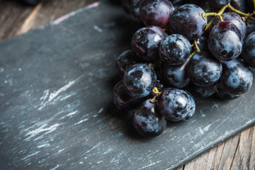 Ripe black grape on the rustic background. Selective focus. Shallow depth of field.