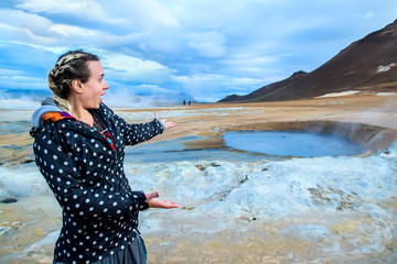 Young woman enjoying the view of geothermal bath in Iceland. Selective focus