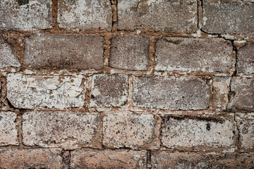 Texture of a brick wall with cracks and scratches which can be used as a background