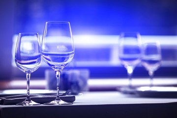 two glasses on the table. luxury restaurant. Red and blue light.