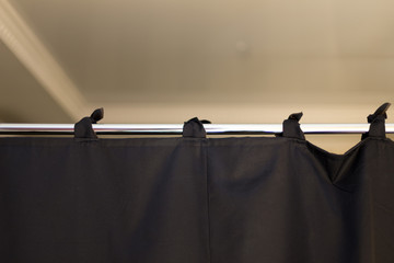 black fabric curtains like a partition on a chrome pipe