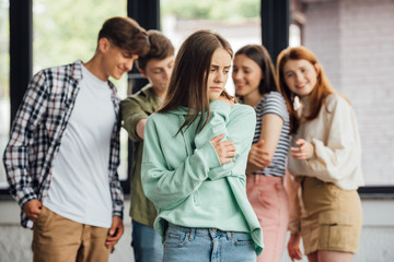 panoramic shot of group of teenagers bullying girl - obrazy, fototapety, plakaty