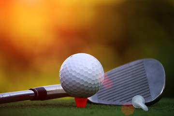 Golf ball and golf club in the evening golf course with sunshine in thailand
