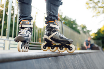 Fototapeta na wymiar Roller skating, male skater standing on ramp