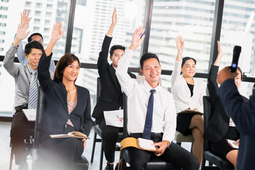 Group of business people raise hands up to ask question and answer to speaker in the meeting room...