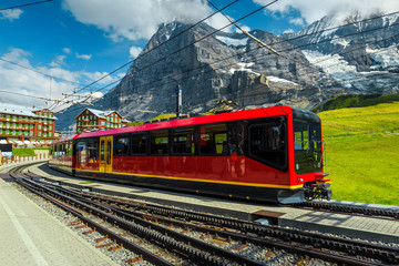 Train station with mountains and modern tourist train, Grindelwald, Switzerland