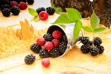 small bucket with raspberries and blackberries