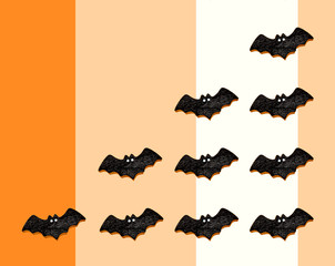 オレンジとベージュと白の3色バックにコウモリを並べてコピースペース