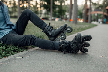 Roller skating, young skater sitting on the ground