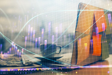 Financial chart drawing and table with computer on background. Multi exposure. Concept of international markets.