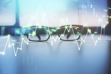 Financial graph hologram with glasses on the table background. Concept of business. Double exposure.