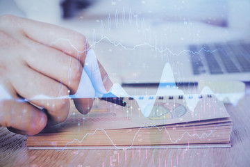 Multi exposure closeup hands with stock market forex graph.