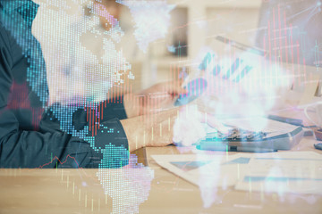 Naklejka premium Double exposure of graph with man typing on computer in office on background. Concept of hard work. Closeup.