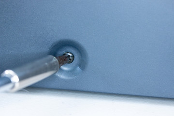 Close up of Phillips screw and hex head screwdriver