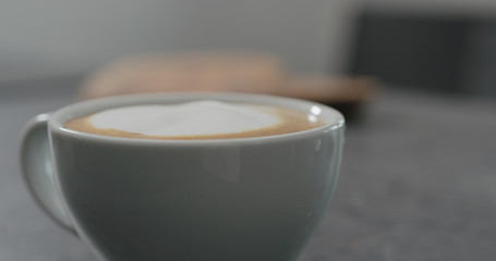 pouring steamed milk anto espresso to make capuccino