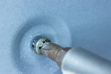 Close up of Phillips screw and hex head screwdriver