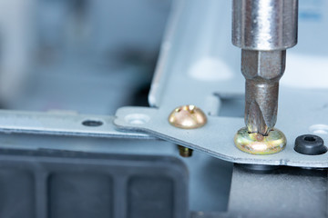 Close up of Phillips screw and hex head screwdriver