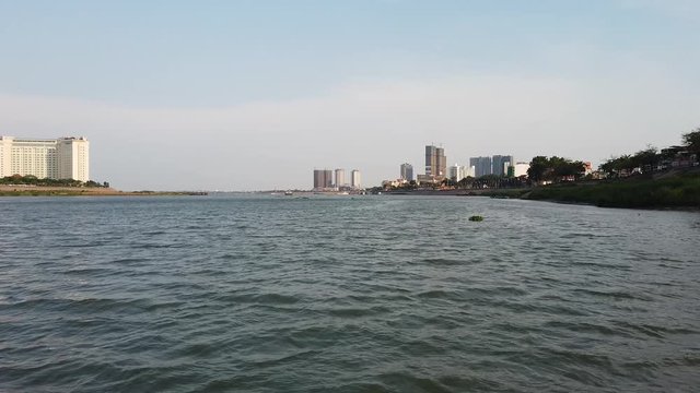 View from moving boat alongside Koh Pich also known as Diamond Island at the junction of the Bassac and Mekong Rivers in Phnom Penh, Cambodia. It is a major luxury development site on reclaimed swamp