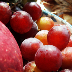 red apple with grapes. on top of the macro. background