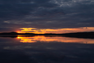 Water reflections at midnight sun at serene lake in finlandd