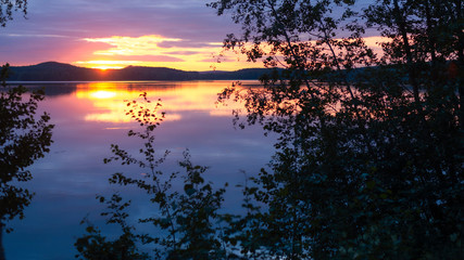 Water reflections at midnight sun at serene lake in finlandd