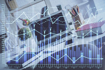Financial graph colorful drawing and table with computer on background. Multi exposure. Concept of international markets.