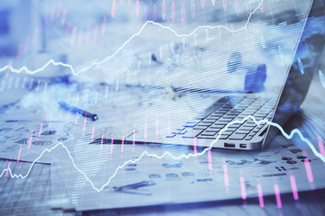 Stock market graph on background with desk and personal computer. Double exposure. Concept of financial analysis.