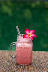 Grapefruit pink shake or smoothie on the table, close up. Breakfast in island Bali, Indonesia