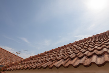 roof top on sky background. Close up of brown clay roof tiles. Red old dirty roof. Old roof tiles. Construction equipment build a house.