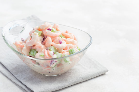 Shrimp, celery and red onion salad in a glass bowl, horizontal,  copy space