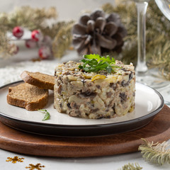 Salad with mushrooms, beef, potatoes and onions for new year, Christmas. Winter holiday, celebration, traditional Russian food. Portion feed