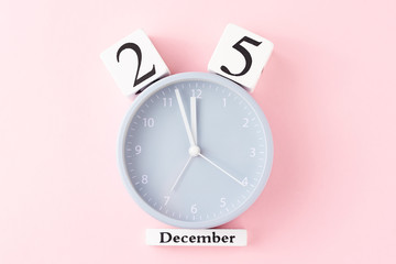Christmas background with alarm clock on pink background