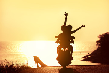 Unrecognizable couple on scooter against sunset sea © cppzone