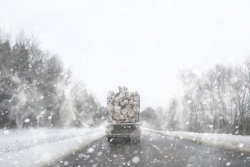 A lorry transports log in the back. Timber truck