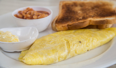 Omelette with toast and baked beans on a plate