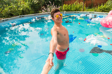 Ecology, plastic trash, environmental emergency and water pollution - guy lead in a pool with garbage