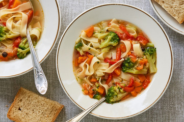 Soup with fresh vegetables and noodles in a white bowl 