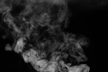 White smoke on a black background. Texture of smoke. Clubs of white smoke on a dark background for an overlay