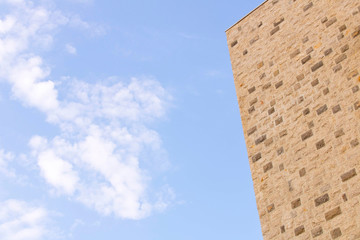 Part of the building against the blue sky. The wall against the blue sky.