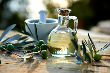 olive oil and green olive on the wooden background