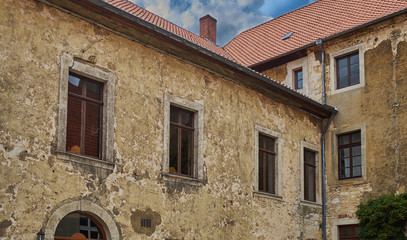 Upper part of the weathered facade of an old manor house