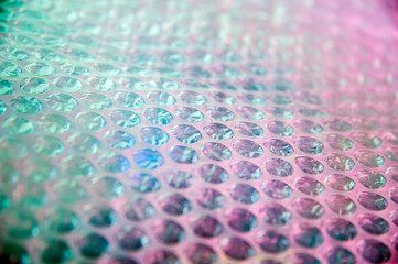 Holographic background in the style of the 80-90s. Real texture of bubble wrap film in bright acid...