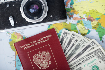 Fototapeta na wymiar A vintage camera, map and international passport as a traveling essentials 