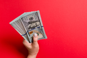 Pack of one hundred dollar bills in femle hands with copy space. Top view of money saving concept on colorful background