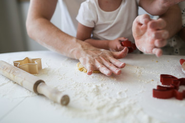 Dad and daughter roll out cookie dough together
