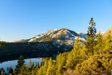 Emerald bay at Lake Tahoe at sunrise with clear blue sky and view of snowcapped mountain in foreround